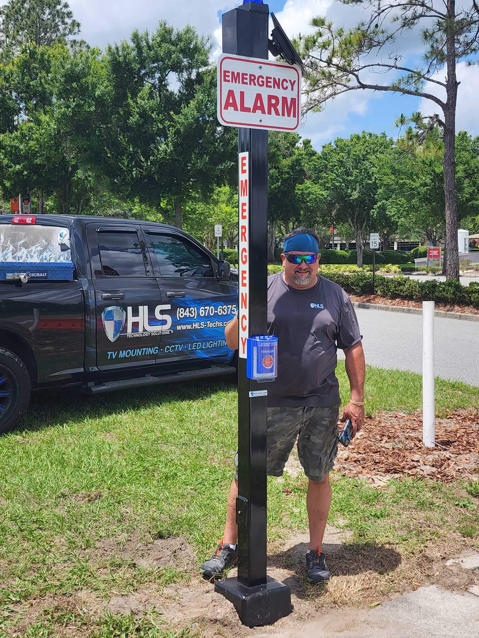 Emergency broadcast service with owner standing beside it and service truck in background