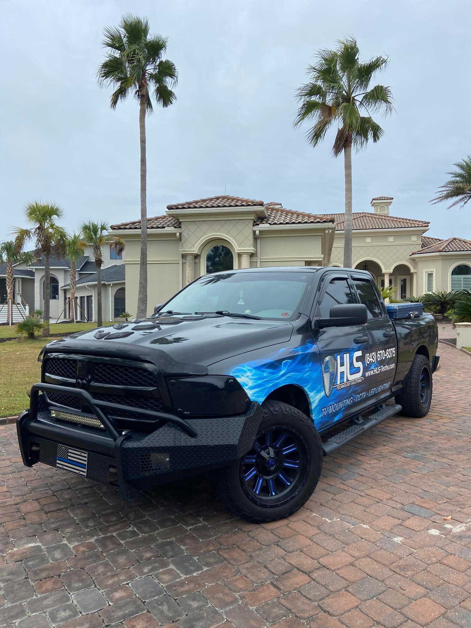 HLS Technologies service truck with home in the background